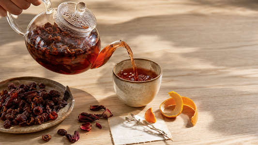 Cascara coffee cherry tea still life with amber infusion, dried coffee cherries, citrus, and warm editorial light.