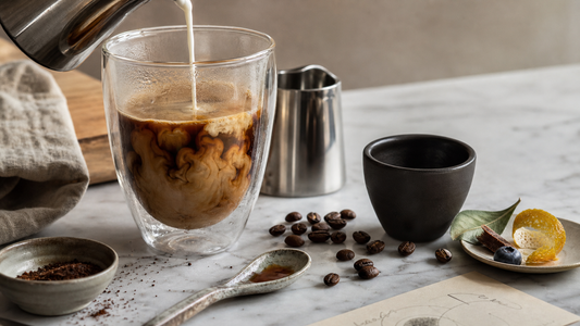 Milk folding into dark coffee in an editorial sensory scene showing how milk changes coffee texture and flavor.